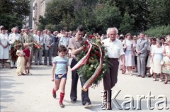 1985, Warszawa, Polska.
Uroczystości związane z odsłonięciem pomnika Ignacego Jana Paderewskiego w nowym miejscu - w Parku Ujazdowskim. Odlana z brązu rzeźba projektu Michała Kamieńskiego od 1978 ustawiona była przy ul. Okólnik, w sąsiedztwie Pałacu Ostrogskich i Państwowej Wyższej Szkoły Muzycznej. W 1985 roku pomnik przeniesiono i ustawionio w nowej lokalizacji, naprzecikwo wejścia do Parku Ujazdowskiego. Na zdjęciu uczestnicy uroczystości składają wieniec pod pomnikiem.
Fot. Edward Grochowicz, zbiory Ośrodka KARTA.