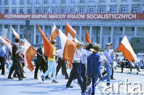 1.05.1987, Warszawa, Polska.
Pochód pierwszomajowy na placu Teatralnym, w głębi slogan propagandowy na fasadzie Teatru Wielkiego.
Fot. Edward Grochowicz, zbiory Ośrodka KARTA