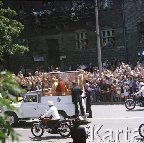 22-23.06.1983, Kraków, Polska.
Druga pielgrzymka papieża Jana Pawła II do Polski w dniach 16-23 czerwca 1983 roku. Przejazd Ojca Świętego ulicami miasta, w papamobile papieżowi towarzyszy arcybiskup metropolita krakowski kardynał Franciszek Macharski.
Fot. Edward Grochowicz, zbiory Ośrodka KARTA