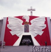 Przed 17.06.1983, Warszawa, Polska.
Przygotowania na Stadionie Dziesięciolecia do wizyty papieża Jana Pawła II podczas drugiej pielgrzymki do Polski. W dniu 17 czerwca 1983 roku Ojciec Święty odprawił w tym miejscu mszę świętą. Nad wejściem na stadion Orzeł Biały z obrazem Matki Boskiej Częstochowskiej, powyżej krzyż stojący obok ołtarza na koronie stadionu.
Fot. Edward Grochowicz, zbiory Ośrodka KARTA