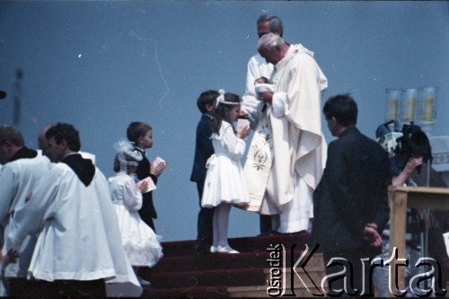 13.06.1987, Łódź, Polska.
Trzecia pielgrzymka papieża Jana Pawła II do Polski w dniach 8-14 czerwca 1987 roku. Msza święta sprawowana przez Ojca Świętego na lotnisku Łódź-Lublinek. Jan Paweł II udziela dzieciom Pierwszej Komunii Świętej.
Fot. Edward Grochowicz, zbiory Ośrodka KARTA