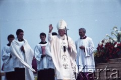 13.06.1987, Łódź, Polska.
Trzecia pielgrzymka papieża Jana Pawła II do Polski w dniach 8-14 czerwca 1987 roku. Msza święta sprawowana przez Ojca Świętego na lotnisku Łódź-Lublinek, podczas której do Pierwszej Komunii Świętej przystąpiło 1600 dzieci. Jan Paweł II pozdrawia wiernych. 1. z prawej ksiądz Piero Marini, Mistrz Papieskich Ceremonii Liturgicznych.
Fot. Edward Grochowicz, zbiory Ośrodka KARTA