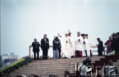 13.06.1987, Łódź, Polska.
Trzecia pielgrzymka papieża Jana Pawła II do Polski w dniach 8-14 czerwca 1987 roku. Msza święta sprawowana przez Ojca Świętego na lotnisku Łódź-Lublinek, podczas której do Pierwszej Komunii Świętej przystąpiło 1600 dzieci. Jan Paweł II pozdrawia wiernych. Obok Ojca Świętego ksiądz Piero Marini, Mistrz Papieskich Ceremonii Liturgicznych.
Fot. Edward Grochowicz, zbiory Ośrodka KARTA