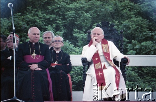 12.06.1987, Gdańsk - Westerplatte, Polska.
Trzecia pielgrzymka papieża Jana Pawła II do Polski w dniach 8-14 czerwca 1987 roku. Spotkanie Ojca Świętego z młodzieżą pod Pomnikiem Obrońców Wybrzeża. Papieżowi towarzyszą (od lewej): arcybiskup metropolita wrocławski kardynał Henryk Gulbinowicz (z tyłu), biskup gdański Tadeusz Gocłowski, ksiądz Piero Marini, Mistrz Papieskich Ceremonii Liturgicznych i arcybiskup metropolita krakowski kardynał Franciszek Macharski.
Fot. Edward Grochowicz, zbiory Ośrodka KARTA