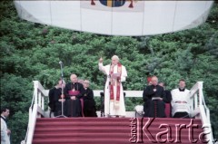 12.06.1987, Gdańsk - Westerplatte, Polska.
Trzecia pielgrzymka papieża Jana Pawła II do Polski w dniach 8-14 czerwca 1987 roku. Ojciec Święty przemawia podczas spotkania z młodzieżą pod Pomnikiem Obrońców Wybrzeża. Janowi Pawłowi II towarzyszą z lewej: arcybiskup metropolita wrocławski kardynał Henryk Gulbinowicz (za mikrofonem), biskup gdański Tadeusz Gocłowski, arcybiskup metropolita krakowski kardynał Franciszek Macharski i ksiądz Piero Marini, Mistrz Papieskich Ceremonii Liturgicznych (z tyłu); z prawej: sekretarz stanu Stolicy Apostolskiej kardynał Agostino Casaroli, z tyłu: sekretarz papieża ksiądz Stanisław Dziwisz i prymas Polski kardynał Józef Glemp.
Fot. Edward Grochowicz, zbiory Ośrodka KARTA