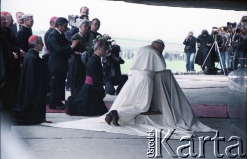 9.06.1987, Lublin, Polska.
Trzecia pielgrzymka papieża Jana Pawła II do Polski w dniach 8-14 czerwca 1987 roku. Wizyta Ojca Świętego w byłym obozie koncentracyjnym w Majdanku. Jan Paweł II modli się w mauzoleum, gdzie złożono prochy zamordowanych więźniów. Obok papieża biskup lubelski Bolesław Pylak, z lewej klęczy arcybiskup metropolita krakowski kardynał Franciszek Macharski.
Fot. Edward Grochowicz, zbiory Ośrodka KARTA