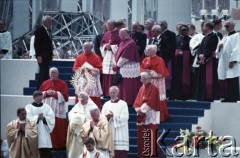 14.06.1987, Warszawa, Polska.
Trzecia pielgrzymka papieża Jana Pawła II do Polski w dniach 8-14 czerwca 1987 roku. Msza święta sprawowana przez Ojca Świętego na placu Defilad. Na dole z lewej prymas Polski kardynał Józef Glemp, z prawej arcybiskup metropolita poznański Jerzy Stroba; obok Jana Pawła II z prawej ksiądz Piero Marini, Mistrz Papieskich Ceremonii Liturgicznych; powyżej z lewej arcybiskup metropolita wrocławski kardynał Henryk Gulbinowicz i sekretarz stanu Stolicy Apostolskiej kardynał Agostino Casaroli; z lewej arcybiskup metropolita krakowski kardynał Franciszek Macharski. W górnym rzędzie 3. z prawej sekretarz papieża ksiądz Stanisław Dziwisz.
Fot. Edward Grochowicz, zbiory Ośrodka KARTA