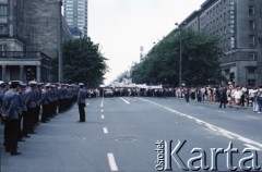 Czerwiec 1987, Warszawa, Polska.
Trzecia pielgrzymka papieża Jana Pawła II do Polski w dniach 8-14 czerwca 1987 roku. Wizyta Ojca Świętego w stolicy. W głębi wierni z transparentami na ulicy Świętokrzyskiej, z lewej milicjanci.
Fot. Edward Grochowicz, zbiory Ośrodka KARTA