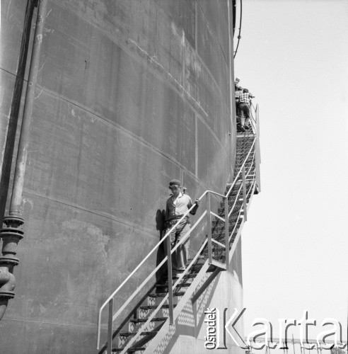 Około 1966, Gdańsk, Polska.
Stocznia Gdańska (od 15.04.1967 Stocznia Gdańska im. Lenina). Pracownicy schodzą po metalowych schodach okalających jeden ze stoczniowych zbiorników.  
Fot. Edward Grochowicz, zbiory Ośrodka KARTA.