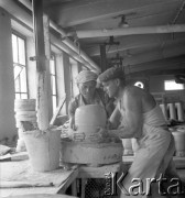 Lata 60. lub 70., Boguchwała, Polska.
Zakłady Porcelany Elektrotechnicznej. Dwaj pracownicy zakladów podczas pracy przy formowaniu masy ceramicznej.
Fot. Edward Grochowicz, zbiory Ośrodka KARTA.