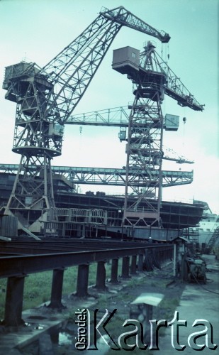 Około 1966, Gdańsk, Polska.
Stocznia Gdańska (od 15.04.1967 Stocznia Gdańska im. Lenina). Budowa statku na jednej z pochylni. Na zdjęciu stoczniowe żurawie.
Fot. Edward Grochowicz, zbiory Ośrodka KARTA.