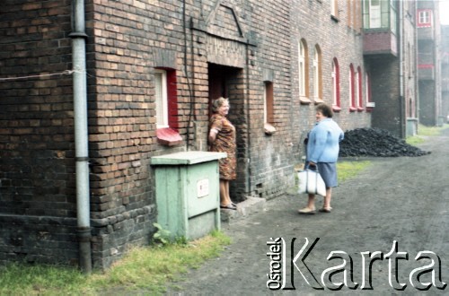 1985, dzielnica Janów-Nikiszowiec, Katowice, Polska. 
Podwórko na zabytkowym osiedlu górniczym Nikiszowiec  w dzielnicy Janów-Nikiszowiec. Dwie kobiety przed wejściem do jednego z familoków. 
Fot. Edward Grochowicz, zbiory Ośrodka KARTA.