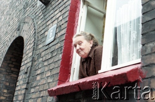 1985, dzielnica Janów-Nikiszowiec, Katowice, Polska.
Zabytkowe górnicze osiedle Nikiszowiec. Kobieta wygląda z okna domu przy ulicy Czechowa 6.  
Fot. Edward Grochowicz, zbiory Ośrodka KARTA.