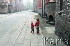 1985, dzielnica Janów-Nikiszowiec, Katowice, Polska.
Zabytkowe górnicze osiedle Nikiszowiec. Dwoje dzieci na chodniku przy jednej z ulic osiedla. 
Fot. Edward Grochowicz, zbiory Ośrodka KARTA.