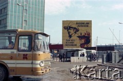 1985, Dąbrowa Górnicza, Polska. 
Pracownicy zakładu przechodzą przez bramki na teren kombinatu metalurgicznego „Huta Katowice”. Po lewej stronie widoczny budynek zarządu przedsiębiorstwa, w głębi kadru transparent z hasłem: ”Budowlani-Hutnikom. Zróbmy więcej niż to wynika z naszych obowiązków”. Na pierwszym planie zaparkowany zakładowy autobus marki Autosan. 
Fot. Edward Grochowicz, zbiory Ośrodka KARTA.