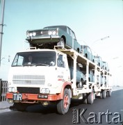 Lata 70. lub 80., Warszawa, Polska.
Fotografia reklamowa dla Przedsiębiorstwa Międzynarodowych Przewozów Samochodowych PEKAES - przygotowane do transportu modele auta Fiat 125p załadowane na lawetę TIR-a.
Fot. Edward Grochowicz, zbiory Ośrodka KARTA.