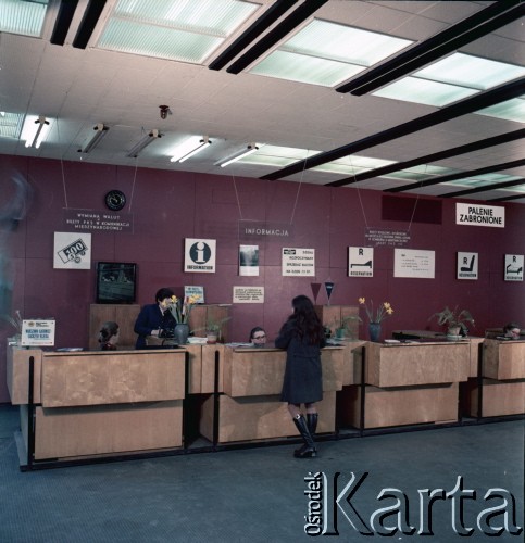 Lata 70. lub 80., Polska.
Fotografia reklamowa dla Centralnego Biura Obsługi Podróżnych PKP POLRES -  klientka przy stanowisku sprzedaży biletów w biurze POLRESU.
Fot. Edward Grochowicz, zbiory Ośrodka KARTA.
