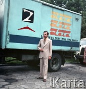 Lata 70., Łódź, Polska.
Spółdzielcze Zakłady Przemysłu Odzieżowego im. J. Lewartowskiego w Łodzi. Fotografia reklamowa - mężczyzna prezentujący garnitur. W tle ciężarówka z hasłem reklamowym 