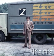 Lata 70., Łódź, Polska.
Spółdzielcze Zakłady Przemysłu Odzieżowego im. J. Lewartowskiego w Łodzi. Fotografia reklamowa - mężczyzna prezentujący garnitur. W tle ciężarówka z hasłem reklamowym 