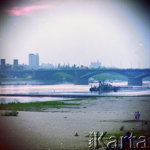 Lata 70., Warszawa, Polska.
Plaża na prawym brzegu Wisły i most Poniatowskiego.
Fot. Edward Grochowicz, zbiory Ośrodka KARTA