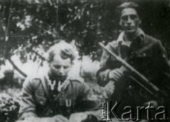 Ok. 1945, Wielkopolska.
Jan Kempiński ps. Błysk – żołnierz ZWZ-AK, żołnierz wyklęty – walczył w  antykomunistycznym podziemiu zbrojnym na terenie Wielkopolski. W 1945 r. aresztowany przez Urząd Bezpieczeństwa i skazany na karę śmierci. Wyrok wykonano w 1946 r. Na zdjęciu z uzbrojonym partyzantem.
Fot. NN, zbiory Ośrodka KARTA, kolekcja Jana Kempińskiego [AW III/566]