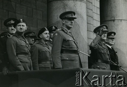 1940-1945, Wielka Brytania.
Polscy i brytyjscy oficerowie na trybunie honorowej. 1. z lewej stoi podpułkownik Wacław Kamionko.
Fot. NN, zbiory Ośrodka KARTA, kolekcja Wacława i Eugenii Kamionko [AW III/711]