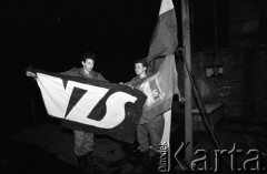 25.09.-2.12.1981, Warszawa, Polska.
Strajk w Wyższej Oficerskiej Szkole Pożarnictwa w Warszawie. Strajkujący walczyli o to, aby WOSP została objęta ustawą o szkolnictwie wyższym. 30 września Rada Ministrów podjęła decyzję o rozwiązaniu uczelni, a 12 grudnia strajk został spacyfikowany. Na zdjęciu: zawieszanie na maszt flagi Niezależnego Zrzeszenia Studentów (NZS).
Fot. NN, zbiory Ośrodka KARTA, przekazali Elżbieta i Jakub Święciccy