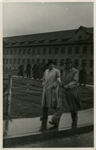 Po 29.04.1945, Murnau am Staffelsee, Bawaria, III Rzesza Niemiecka.
Mężczyźni spacerują po wyzwolonym przez wojska amerykańskie niemieckim obozie jenieckim Oflag Murnau VII A. Za nimi widać grupę żołnierzy. 
Fot. NN, kolekcja Marcina Rudzińskiego, zbiory Ośrodka KARTA