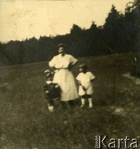 Lata 20., Rzeczpospolita Polska.
Kobieta z dziećmi na łące. 1. z lewej stoi mała Larysa Zajączkowska.
Fot. NN, kolekcja Larysy Zajączkowskiej-Mitznerowej, zbiory Ośrodka KARTA