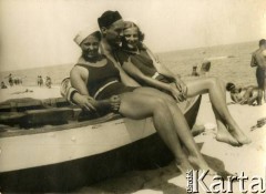 Lato 1938, Jastarnia lub Gdynia, woj. pomorskie, Rzeczpospolita Polska.
Larysa Zajączkowska (z lewej) z przyjaciółmi siedzą na łodzi na plaży nad Morzem Bałtyckim.  
Fot. NN, kolekcja Larysy Zajączkowskiej-Mitznerowej, zbiory Ośrodka KARTA