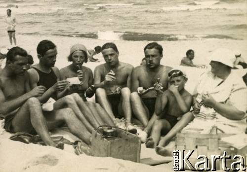 Lato 1938, Jastarnia lub Gdynia, woj. pomorskie, Rzeczpospolita Polska.
Larysa Zajączkowska (3. z lewej) z rodziną i przyjaciółmi podczas posiłku na plaży nad Morzem Bałtyckim. 1. z prawej siedzi jej babcia - Larysa Michelson, 2. brat Jerzy. 
Fot. NN, kolekcja Larysy Zajączkowskiej-Mitznerowej, zbiory Ośrodka KARTA