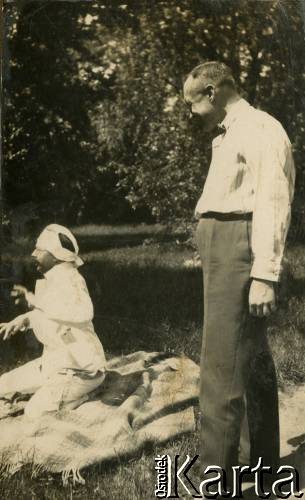 Lata 20., Rzeczpospolita Polska.
Mężczyzna siedzący na kocu. Stoi Piotr Zajączkowski (ojciec Larysy).
Fot. NN, kolekcja Larysy Zajączkowskiej-Mitznerowej, zbiory Ośrodka KARTA