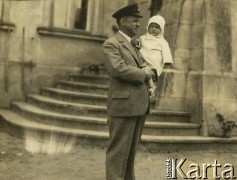 Lata 20., Rzeczpospolita Polska.
Mężczyzna trzyma na rękach dziecko.
Fot. NN, kolekcja Larysy Zajączkowskiej-Mitznerowej, zbiory Ośrodka KARTA