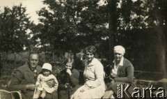 Ok. 1929, Olszanka, woj. warszawskie, Rzeczpospolita Polska.
Rodzina Zajączkowskich podczas odpoczynku w ogrodzie wynajmowanego domku letniskowego w Puszczy Mariańskiej. Siedzą od lewej: ojciec Larysy Piotr z synem Jerzym na kolanach, Larysa, NN, matka Elżbieta.
Fot. NN, kolekcja Larysy Zajączkowskiej-Mitznerowej, zbiory Ośrodka KARTA