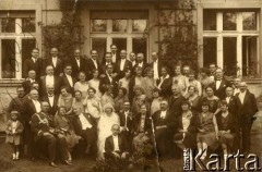 Lata 30., Olszanka, woj. warszawskie, Rzeczpospolita Polska.
Goście zaproszeni na ślub córki profesora Henryka Galle, Elżbiety (siedzi w pierwszym rzędzie 4. z lewej, obok mąż).  Za państwem młodym 8. z lewej stoi Elżbieta Zajączkowska. W ostatnim rzędzie 3. z lewej stoi Piotr Zajączkowski. Zdjęcie wykonane na tle dworu profesorstwa Galle. 
Fot. NN, kolekcja Larysy Zajączkowskiej-Mitznerowej, zbiory Ośrodka KARTA