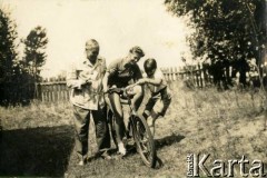 Lato 1939, Moszczenica, woj. łódzkie, Rzeczpospolita Polska.
Piotr Zajączkowski, ojciec Larysy, Larysa (na rowerze) i brat Jerzy w ogrodzie wynajętego domku letniskowego.
Fot. NN, kolekcja Larysy Zajączkowskiej-Mitznerowej, zbiory Ośrodka KARTA