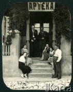 1936-1939, Puszcza Mariańska, woj. warszawskie, Rzeczpospolita Polska.
Larysa Zajączkowska (2. z prawej) siedzi z rodziną i przyjaciółmi przed wejściem do apteki.
Fot. NN, kolekcja Larysy Zajączkowskiej-Mitznerowej, zbiory Ośrodka KARTA

