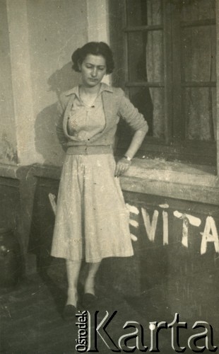 Lata 50., Santa Ana, prowincja Misiones, Argentyna.
Silvia Szymula przy napisie Evita. W dniu zakończenia II wojny światowej wyszła za mąż za Stefana Szymulę, polskiego żołnierza, który stacjonował w jej rodzinnym miasteczku Dicomano (Włochy) we Włoszech. Po wojnie wyjechali do Argentyny. 
Fot. NN, zbiory Silvii Szymuli, reprodukcje cyfrowe w  Bibliotece Polskiej im. Ignacego Domeyki w Buenos Aires (Biblioteca Polaca Ignacio Domeyko) i w Ośrodku KARTA w Warszawie
