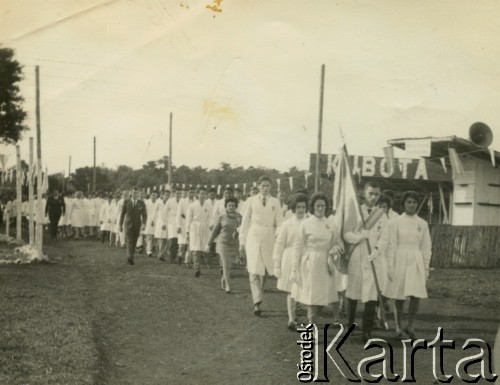 Ok. 1964., Puerto Rico, prowincja Misiones, Argentyna.
Claudio Szymula niesie flagę w czasie uroczystości szkolnej. Jego rodzice wzięli ślub w dniu zakończenia wojny. W 1948 roku emigrowali do Argentyny.
Fot. NN, zbiory Silvii Szymuli, reprodukcje cyfrowe w  Bibliotece Polskiej im. Ignacego Domeyki w Buenos Aires (Biblioteca Polaca Ignacio Domeyko) i w Ośrodku KARTA w Warszawie