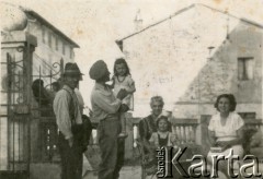 1944-1948, Scaperzano, Włochy.
Stefan Szymula z mieszkańcami miasteczka. Przed wojną pracował w Powiatowym Zarządzie Drogowym w Buczaczu, po 1939 ukrywał się. Aresztowany po nieudanej ucieczce do Rumunii, osadzony w więzieniu w Czortkowie, później w Starobielsku. Skazany na 5 lat obozu, zesłany w styczniu 1941 roku na Syberię. Dostał się do Armii Andersa, z którą został ewakuowany do Iranu. Przeszedł z nią cały szlak bliskowschodni. W Palestynie ukończył Szkołę Podchorążych Piechoty Rezerwy i został mianowany porucznikiem. Walczył pod Monte Cassino. W 1948 roku emigrował z żoną i synkiem do Argentyny.
Fot. NN, zbiory Silvii Szymuli, reprodukcje cyfrowe w  Bibliotece Polskiej im. Ignacego Domeyki w Buenos Aires (Biblioteca Polaca Ignacio Domeyko) i w Ośrodku KARTA w Warszawie