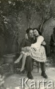1945, Dicomano, Włochy.
Silvia Szymula z domu Valli i Stefan Szymula. S. Szymula przed wojną pracował w Powiatowym Zarządzie Drogowym w Buczaczu, po 1939 ukrywał się. Aresztowany po nieudanej ucieczce do Rumunii, osadzony w więzieniu w Czortkowie, później w Starobielsku. Skazany na 5 lat obozu, zesłany w styczniu 1941 roku na Syberię. Dostał się do Armii Andersa, z którą został ewakuowany do Iranu. Przeszedł z nią cały szlak bliskowschodni. W Palestynie ukończył Szkołę Podchorążych Piechoty Rezerwy i został mianowany porucznikiem. Walczył pod Monte Cassino. W 1948 roku emigrował z żoną i synkiem do Argentyny. Nz. Silvia w stroju ludowym stylizowanym na polski, który sama uszyła.
Fot. NN, zbiory Silvii Szymuli, reprodukcje cyfrowe w  Bibliotece Polskiej im. Ignacego Domeyki w Buenos Aires (Biblioteca Polaca Ignacio Domeyko) i w Ośrodku KARTA w Warszawie