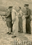 1945-1947, Urbino, Włochy.
Ćwiczenia na poligonie wojskowym. Silvia Szymula z domu Valli (celuje z karabinu) i Stefan Szymula (2. z prawej). S. Szymula przed wojną pracował w Powiatowym Zarządzie Drogowym w Buczaczu, po 1939 ukrywał się. Aresztowany po nieudanej ucieczce do Rumunii, osadzony w więzieniu w Czortkowie, później w Starobielsku. Skazany na 5 lat obozu, zesłany w styczniu 1941 roku na Syberię. Dostał się do Armii Andersa, z którą został ewakuowany do Iranu. Przeszedł z nią cały szlak bliskowschodni. W Palestynie ukończył Szkołę Podchorążych Piechoty Rezerwy i został mianowany porucznikiem. Walczył pod Monte Cassino. W 1948 roku emigrował z żoną i synkiem do Argentyny.
Fot. NN, zbiory Silvii Szymuli, reprodukcje cyfrowe w  Bibliotece Polskiej im. Ignacego Domeyki w Buenos Aires (Biblioteca Polaca Ignacio Domeyko) i w Ośrodku KARTA w Warszawie