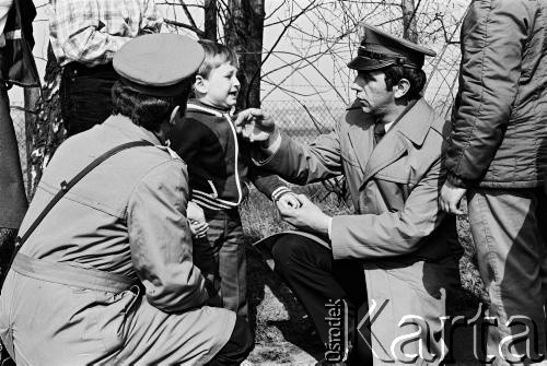 1984, Ostrzeszów, woj. kaliskie, Polska. 
Zawody sportowe: Cross Ostrzeszowski. Milicjanci z dzieckiem, które się zagubiło.
Fot. Stanisław Kulawiak, zbiory Ośrodka KARTA.