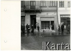 1941, Rzeszów, dystrykt krakowski, Generalne Gubernatorstwo.
Getto żydowskie. Zlikwidowany zakład usługowy przy Marktplatz 19 (obecnie Rynek). Na chodniku grupa ludzi z opaskami żydowskimi.
Fot. NN, kolekcja Bogusława Kotuli, zbiory Fundacji Ośrodka KARTA
