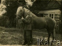 Lata 30., Iszkołdź, woj. nowogródzkie, Polska.
Zygmunt Osipowicz, ojciec Heleny Rozumko, z koniem przed domem.
Fot. NN, zbiory Archiwum Historii Mówionej Ośrodka KARTA i Domu Spotkań z Historią, udostępniła Helena Rozumko w ramach projektu 