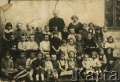 Przed 1939, Republika Łotewska.
Zdjęcie grupowe dzieci z księdzem. Fotografia z rodzinnego archiwum Bogumiły Dmuchowskiej (z d. Wróblewskiej).
Fot. NN, zbiory Archiwum Historii Mówionej Ośrodka KARTA i Domu Spotkań z Historią, udostępniła Bogumiła Dmuchowska w ramach projektu 