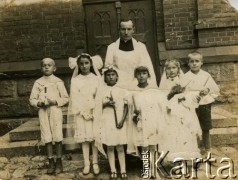 1938, Iwieniec, woj. nowogródzkie, Polska.
Pamiątka I Komunii Świętej. Od lewej stoją: Tomasz Arciszewski, Helena Bórak, Maria Jaroczka, Mela Timoszanko, Genowefa Kulwanowska, u góry o. Kazimierz.
Fot. NN, zbiory Archiwum Historii Mówionej Ośrodka KARTA i Domu Spotkań z Historią, udostępnili Maria i Leonard Mikuccy w ramach projektu 