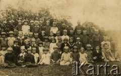 1936, Iwieniec, Polska.
Zdjęcie grupowe dzieci z opiekunką. Weronika Ciaszkiewicz siedzi 1. z lewej w 1. rzędzie ubrana na czarno.
Fot. NN, zbiory Archiwum Historii Mówionej Ośrodka KARTA i Domu Spotkań z Historią, udostępniła Weronika Juchniewicz w ramach projektu 