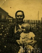 Lata 30., prawdopodobnie Równe, woj. wołyńskie, Polska.
Kobieta z dzieckiem w ogrodzie. Fotografia z rodzinnego archiwum Marii Kamińskiej z domu Herflisz.
Fot. NN, zbiory Archiwum Historii Mówionej Ośrodka KARTA i Domu Spotkań z Historią, udostępniła Maria Kamińska w ramach projektu 