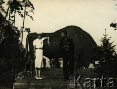 Przed 1939, Spała, woj. warszawskie, Polska.
Zdjęcie pamiątkowe ze spalskim żubrem. W tle widoczna jest letnia rezydencja Prezydenta RP.
Fot. NN, zbiory Archiwum Historii Mówionej Ośrodka KARTA i Domu Spotkań z Historią, udostępnił Jerzy Maracz w ramach projektu 